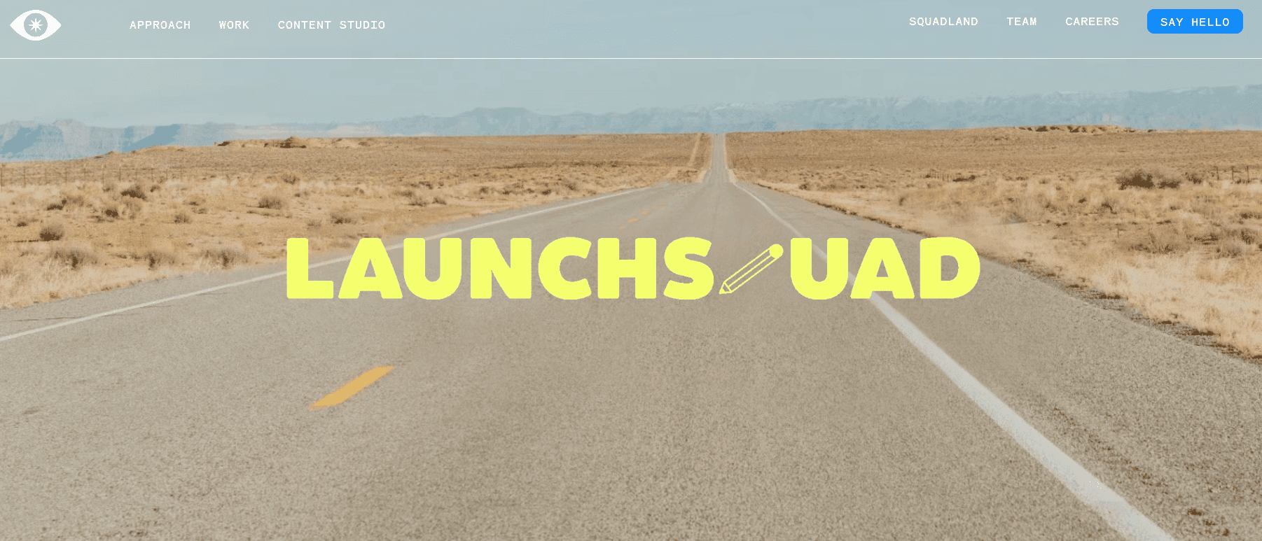 LaunchSquad agency homepage featuring a desert highway background, bold branding, and navigation links for public relations, content strategy, creative work, and company information.