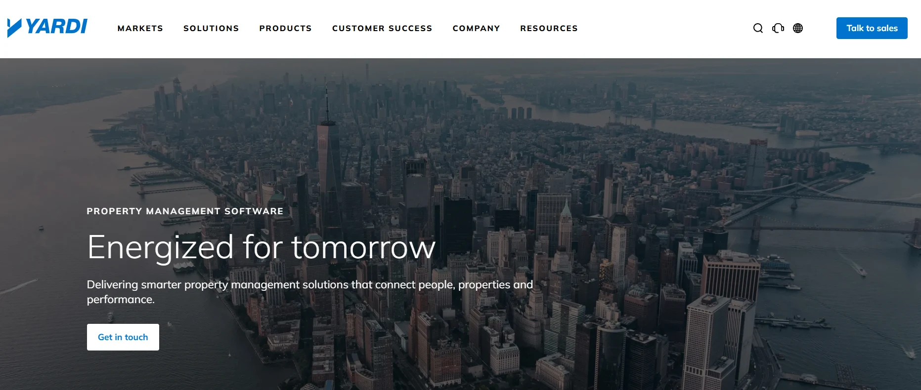 Yardi property management software homepage featuring an aerial city view and solutions for connecting people, properties, and performance.